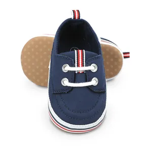 Detailzicht van donkerblauwe baby wandelschoenen met een noppenzool en streepjes
