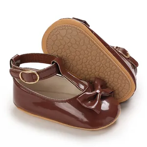 Detailansicht brauner Baby-Mädchenschuhe aus Lackleder mit Schleife und T-Riemen