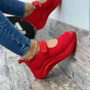 Détail de baskets en maille rouge vif avec semelle plateforme épaisse et sangle velcro