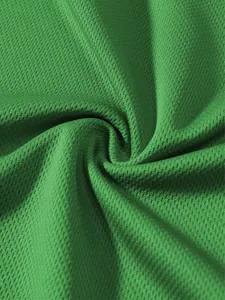 Primo piano del tessuto a rete traspirante verde che mostra la texture sportiva