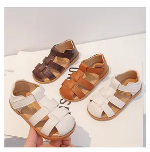 Detalle de sandalias infantiles trenzadas cerradas en color blanco, marrón y tan