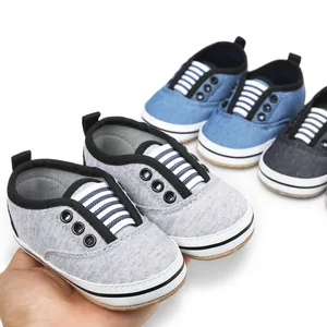 Detailed close-up of soft fabric infant pre-walker shoes in grey and blue colors