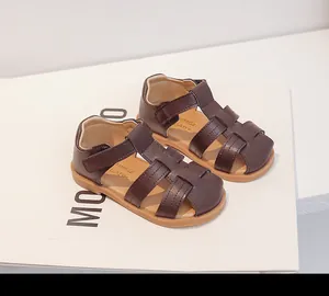 Detalle de sandalias trenzadas marrones para niños con suelas de goma blandas para el verano.