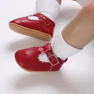 Detailed macro view of red baby Mary Jane shoes featuring a soft rubber sole and buckle