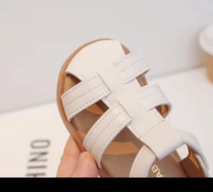 Primer plano de sandalias de cuero trenzado blanco para niños pequeños y bebés