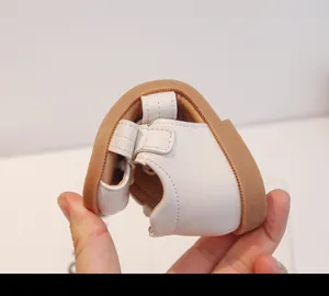 Primer plano que muestra la suela ultra suave y flexible de las sandalias blancas bebé