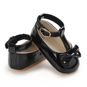 Detailaufnahme schwarzer Lackleder-Babyschuhe für Mädchen mit Knöchelriemen und Schleife