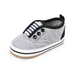 Detailed view of a grey canvas baby walker shoe with soft sole and striped tongue.