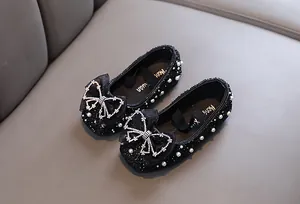 Detailaufnahme schwarze Prinzessinnenschuhe für Mädchen mit glitzernder Schleife