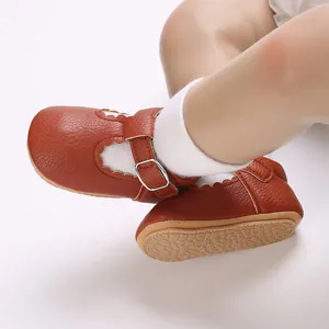 Detail of brown leather baby walker shoes with T-strap and soft rubber sole