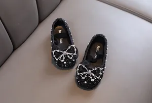 Detailansicht schwarzer glitzernder Prinzessinnenschuhe für Mädchen mit Schleife.
