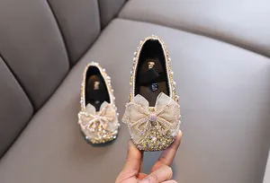 Detailansicht goldene Prinzessinnenschuhe für Mädchen mit Strass und großer Schleife