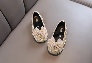 Glitzernde goldene Mädchen-Prinzessin-Schuhe mit Strass-Schleife und Perlen-Verzierung.