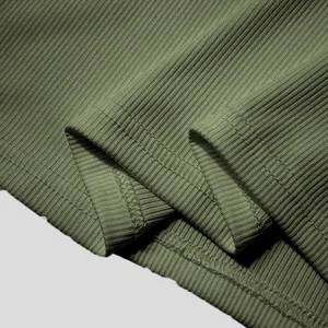 Close-up macro view of the double-stitched hem on olive green ribbed knit men's tank top