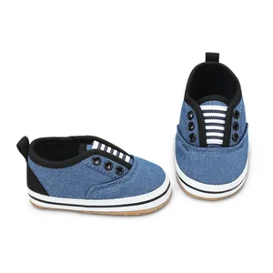 Detailed macro view of blue denim baby pre-walker shoes on a clean white background