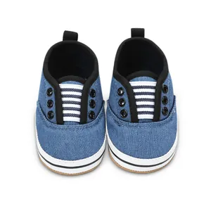 Close-up of blue denim baby walker shoes with black trim and striped tongue