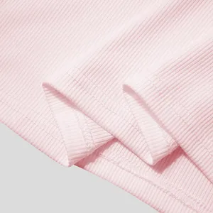 Macro detail view of pink ribbed fabric showing neat double-needle stitching on hem
