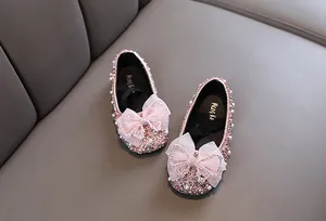 Detailaufnahme von rosa glitzernden Prinzessinnenschuhen mit großen Zierschleifen