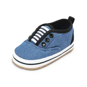 Detail shot of a blue denim baby walking shoe featuring striped elastic bands