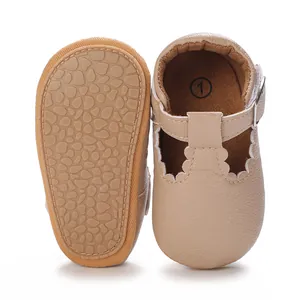 Detail view of beige baby walking shoes with soft scalloped edges and non-slip rubber soles.