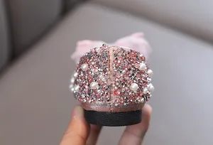 Detailansicht der glitzernden Strass- und Perlenferse an Mädchen-Prinzessin-Tanzschuhen.