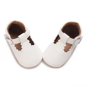 Detailed macro view of white baby walking shoes with scalloped edges and soft rubber soles