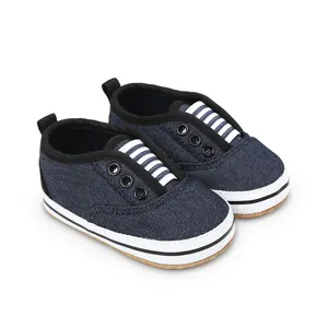 Detail view of dark blue denim baby pre-walker shoes with white soles and striped accents.