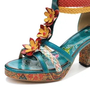 Close-up detail showing floral decorations on retro hand-colored leather sandals.