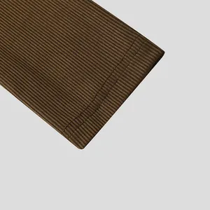 Detailed macro view of brown ribbed knit fabric and double-stitched hem on a men's shirt