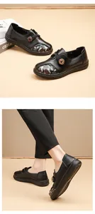 Detail view of black floral leather shoes for elderly women with soft non-slip soles.