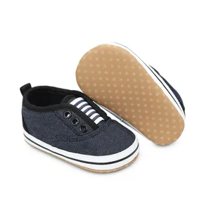 Close-up detail of navy canvas baby pre-walker shoes featuring non-slip dotted soles