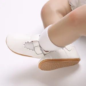 Macro view of white baby princess shoes with soft rubber soles and buckle straps