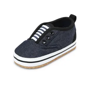 Close-up of navy blue denim baby walking shoes with striped elastic tongue.