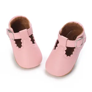 Close-up of pink baby Mary Jane shoes with delicate scalloped edges and buckle strap
