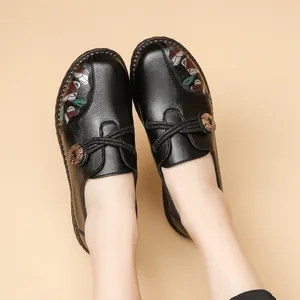 Comfortable black leather mama shoes with soft soles, floral print, and wood button.