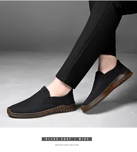 Detalle lateral de mocasines negros para hombre con diseño slip-on y suela cosida