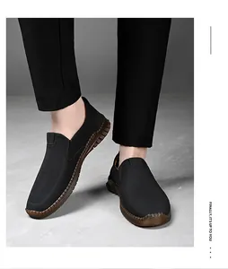 Detalle de mocasines negros para hombre con cuero suave y costuras hechas a mano sin cordones.