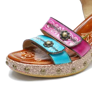 Gedetailleerd overzicht van vintage leren sandalen met bloemmotief klinknagels