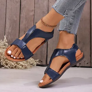 Detailopname van navyblauwe casual platte sandalen met klittenband op de voeten van model