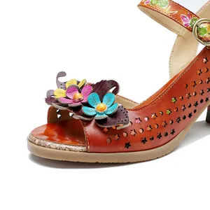 Close-up of handmade leather flowers and hollow-out star patterns on brown sandal