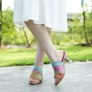 Dettaglio ravvicinato di sandali vintage in pelle patchwork con tacco alto indossati fuori