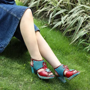 Detail of handmade vintage leather sandals with hollow-out floral design in a garden setting