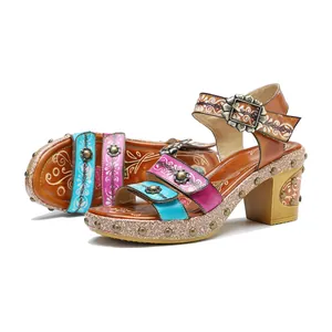 Detail van vintage leren sandalen met kleurrijke bloemenbandjes en klinknagels.