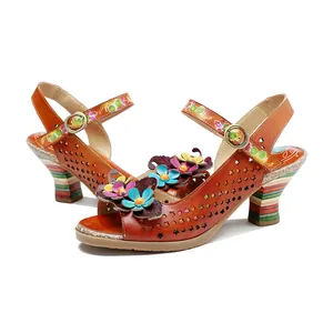 Detailed view of handmade leather sandals with 3D flowers and perforated patterns.