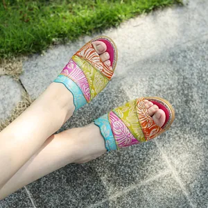 Primo piano di sandali vintage in vera pelle patchwork con motivo floreale inciso