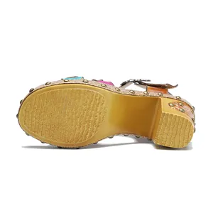 Gedetailleerd zicht op de getextureerde zool en blokhak van de retro lederen sandalen