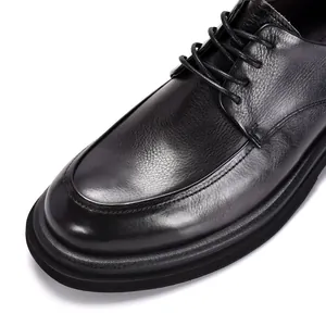Close-up detail van zwarte leren Derby-schoen met getextureerde afwerking en dikke zool