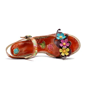 Macro detail view of handmade leather sandal featuring 3D colorful flowers and ethnic patterns