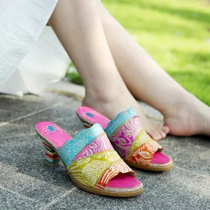 Dettaglio di sandali vintage in pelle fatti a mano con goffratura floreale e tacco a blocco