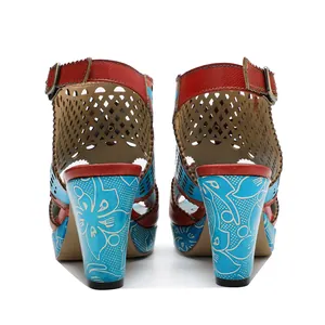 Detail of retro handmade leather sandals with hollow-out pattern and blue floral heels